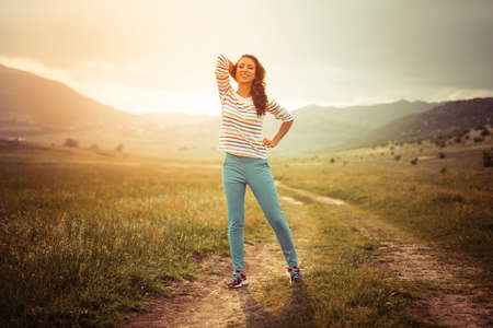 Beautiful girl standing on the rural roadの写真素材