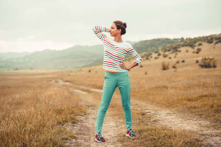 Beautiful girl standing on the rural roadの写真素材