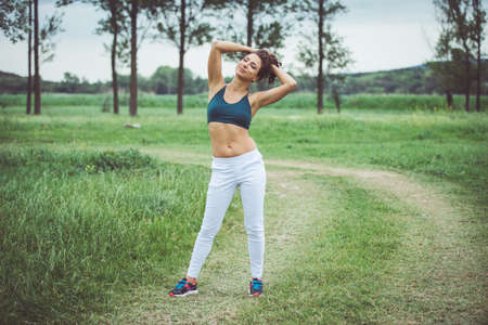 Beautiful sporty girl standing outdoor at the natureの写真素材