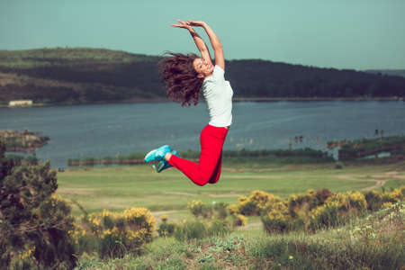 Beautiful girl jumping outdoor. Happiness and freedom concept. Toned imageの写真素材