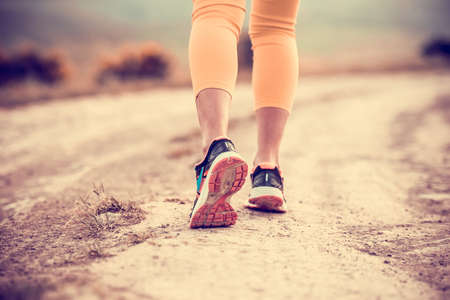 Walking or running legs on trail, adventure and exercising concept. Toned imageの写真素材