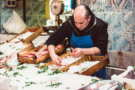 PALERMO, ITALY - MARCH 13, 2015: Vendor selling seafood and fish at famous local market Ballaro in Palermo, Italyのeditorial素材