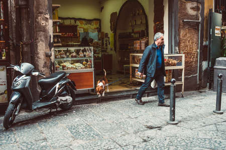 NAPLES, ITALY - MARCH 20, 2015: People walking through the old street  in the historical center of Naples, Italy. Selective focusのeditorial素材