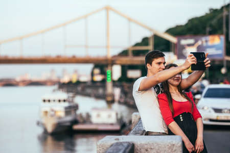KIEV (KYIV), UKRAINE - MAY 25, 2015: Young couple making selfie near bridge and the Dnepr (Dnieper) river in Kiev, Ukraineのeditorial素材