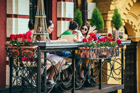 KIEV, UKRAINE - MAY 25, 2015: Young women  chatting and eating at the outside terrace of small cafe in Kiev, Ukraineのeditorial素材