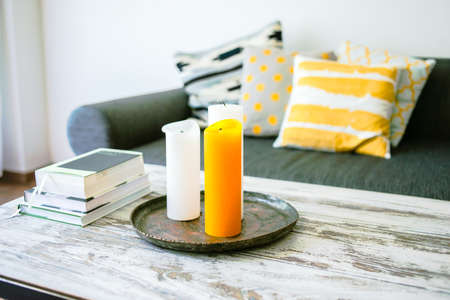 Modern wooden coffee table and cozy sofa with pillows. Living room interior and home decor conceptの写真素材