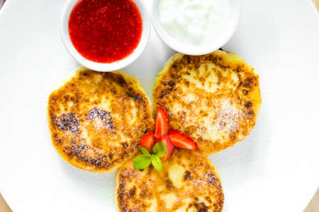 Cottage cheese pancakes with sour cream and strawberry sauceの写真素材