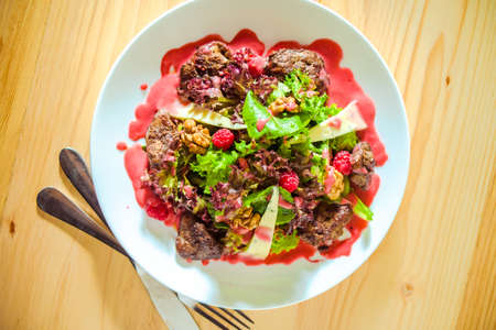 Fresh summer salad with chicken liver, blue cheese in raspberry sauceの写真素材
