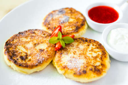 Cottage cheese pancakes with sour cream and strawberry sauceの写真素材