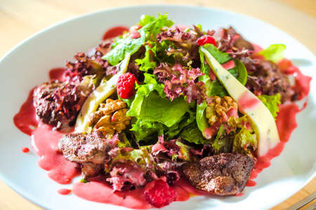 Fresh summer salad with chicken liver, blue cheese in raspberry sauceの写真素材