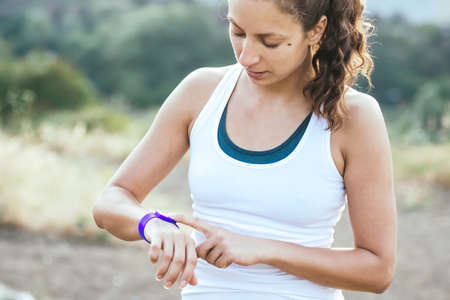 Woman using activity tracker. Outdoor fitness conceptの写真素材