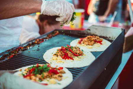 Preparation of fajitas, mexican beef with grilled vegetable in tortilla wraps. Street food and outdoor cooking conceptの写真素材