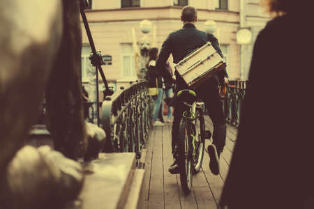 Man riding the bicycle over the Bank Bridge (Bankovsky most) in Saint Petersburg, Russiaの写真素材