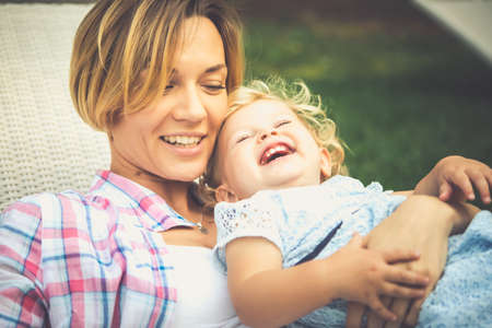 Young beautiful mother has fun with her daughter during a walk outdoors. Toned imageの写真素材