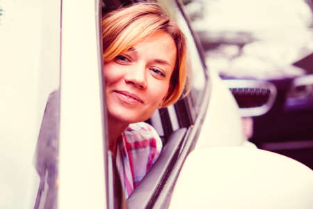 Young beautiful blonde woman drives a car. Toned imageの写真素材
