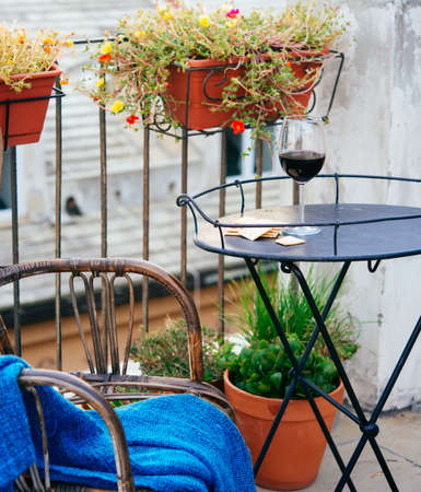 Beautiful terrace or balcony with small iron table, chair and wine glassの写真素材