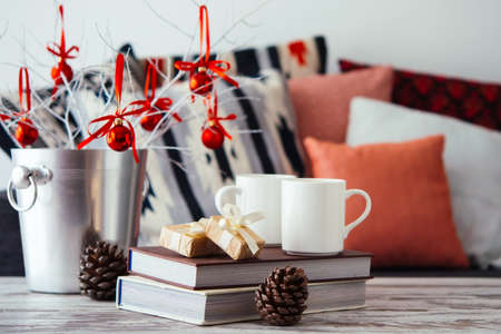 Christmas or new year decoration on modern wooden coffee table. Cozy sofa with pillows on a background. Living room interior and holiday home decor conceptの写真素材