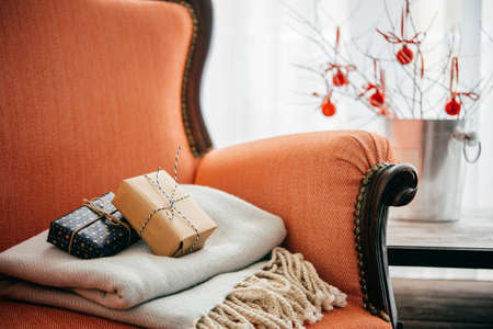 Gifts and warm plaid on cozy retro armchair. Christmas or new year decoration conceptの写真素材