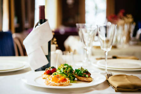 Plate of assorted Italian appetizer bruschetta with chopped vegetables, salmon and meat on ciabatta...