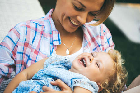 Young beautiful mother has fun with her daughter during a walk outdoors. Toned imageの写真素材