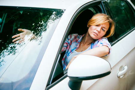 Young woman gets annoyed while driving the car in traffic jamの写真素材