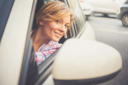 Young beautiful blonde woman drives a car. Toned imageの写真素材
