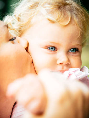 Young beautiful  mother kisses her daughterの写真素材