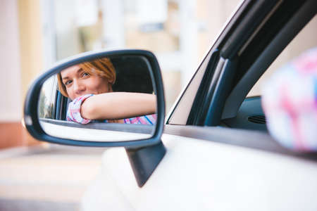 Young beautiful blonde woman drives a carの写真素材