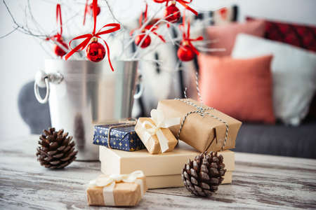 Christmas or new year decoration on modern wooden coffee table. Cozy sofa with pillows on a background. Living room interior and holiday home decor conceptの写真素材