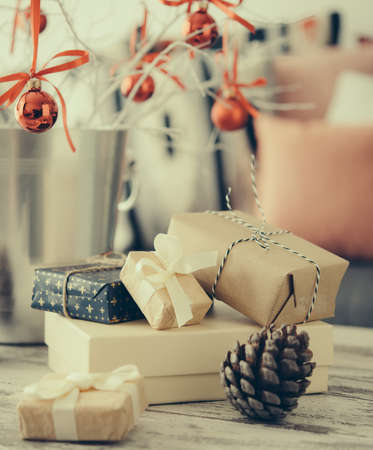 Christmas or new year decoration on modern wooden coffee table. Cozy sofa with pillows on a background. Living room interior and holiday home decor concept. Toned pictureの写真素材