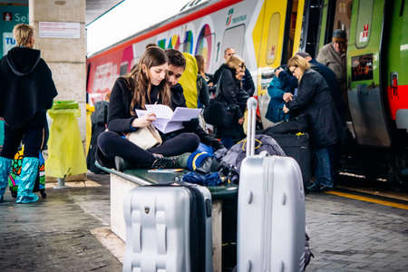 VENICE, ITALY - OCTOBER 14, 2015: Young couple sits near the train at St. Lucia railway station in Venice, Italy.のeditorial素材