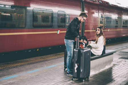 VENICE, ITALY - OCTOBER 14, 2015: Young couple sits near the train at St. Lucia railway station in Venice, Italy. Toned pictureのeditorial素材