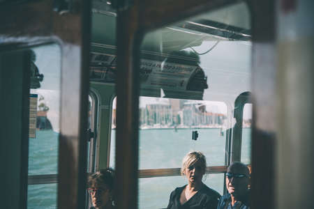 VENICE, ITALY - OCTOBER 12, 2015: Reflections of passengers are seen in vaporetto windows in Venice, Italy. Toned pictureのeditorial素材