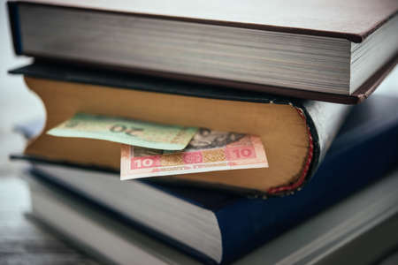 Pile of books and ukrainian hryvnia billsの写真素材