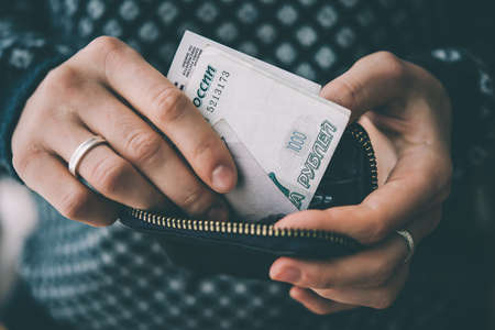 Hands holding russian rouble bills and small money pouch. Toned pictureの写真素材