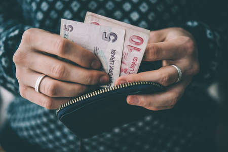 Hands holding turkish lira bills and small money pouch. Toned pictureの写真素材
