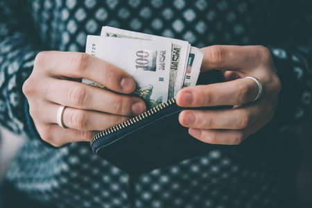 Hands holding georgian lari bills and small money pouch. Toned pictureの写真素材