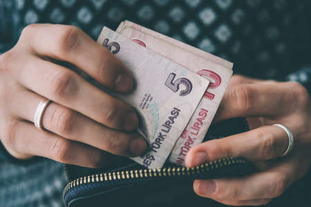 Hands holding turkish lira bills and small money pouch. Toned pictureの写真素材