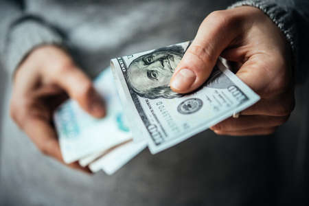 Hands holding russian rouble and us dollar billsの写真素材