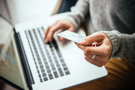 Hands holding plastic credit card and using laptop. Online shopping conceptの写真素材