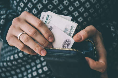 Hands holding russian rouble bills and small money pouch. Toned pictureの写真素材