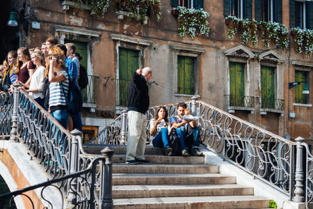 VENICE, ITALY - OCTOBER 12, 2015: Tourists at one of the bridges of Venice, Italyのeditorial素材