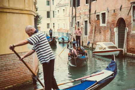 VENICE, ITALY - OCTOBER 11, 2015: Tourists are taking a gondola ride on the canals of Venice, Italy. Toned pictureのeditorial素材