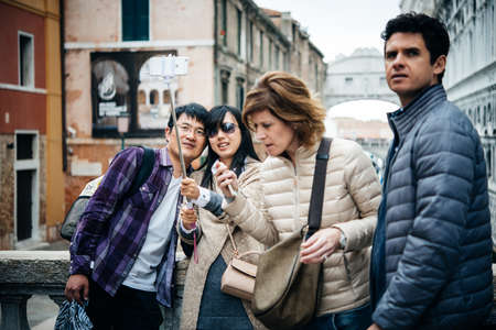 VENICE, ITALY - OCTOBER 12, 2015: Tourists are taking selfie at one of the bridges in Venice, Italyのeditorial素材