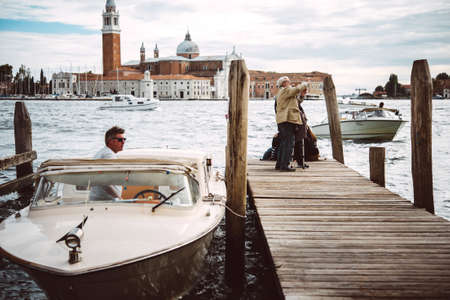 VENICE, ITALY - OCTOBER 12, 2015: Tourists are viewing Grand Canal with San Giorgio Maggiore island in the background in Venice, Italyのeditorial素材
