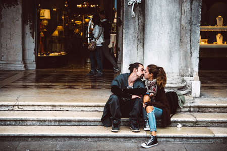 VENICE, ITALY - OCTOBER 12, 2015: Romantic young couple is kissing at San Marco square in Venice, Italyのeditorial素材