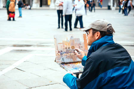 VENICE, ITALY - OCTOBER 12, 2015: A painter is drawing at San Marco square in Venice, Italyのeditorial素材