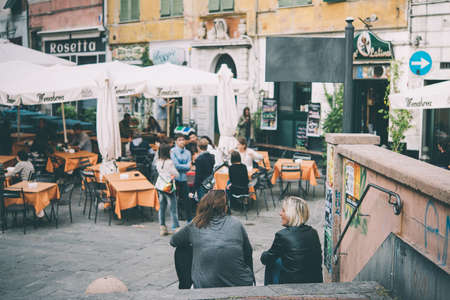 GENOA, ITALY - OCTOBER 8, 2015: People are sitting at the outside terrace of a small cafe in the historic centre of Genoa, Italy. Toned pictureのeditorial素材