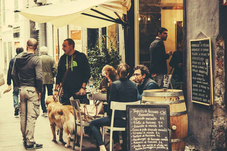 GENOA, ITALY - OCTOBER 8, 2015: People are sitting at the outside terrace of a small cafe in the historic centre of Genoa, Italy. Toned pictureのeditorial素材