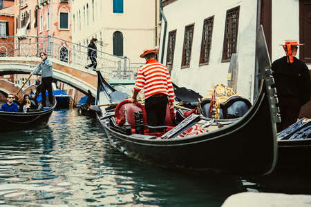 VENICE, ITALY - OCTOBER 11, 2015: Tourists are taking a gondola ride on the canals of Venice, Italy. Toned pictureのeditorial素材